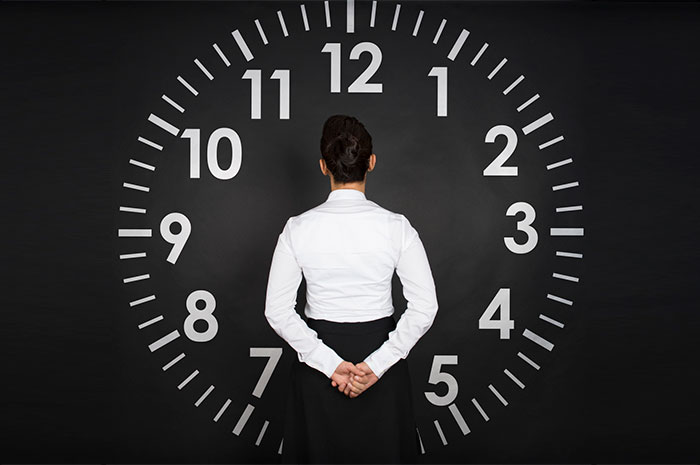 woman in front of clock