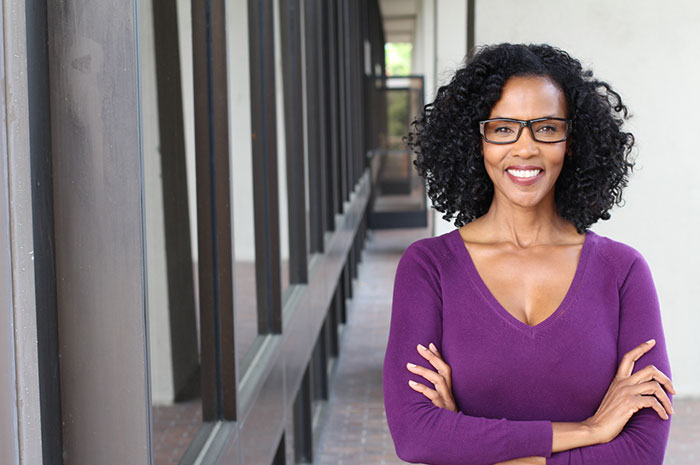 Female Entrepreneur wearing purple top and glasses