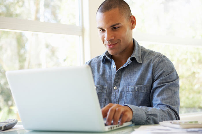 man on laptop wearing denim shirt